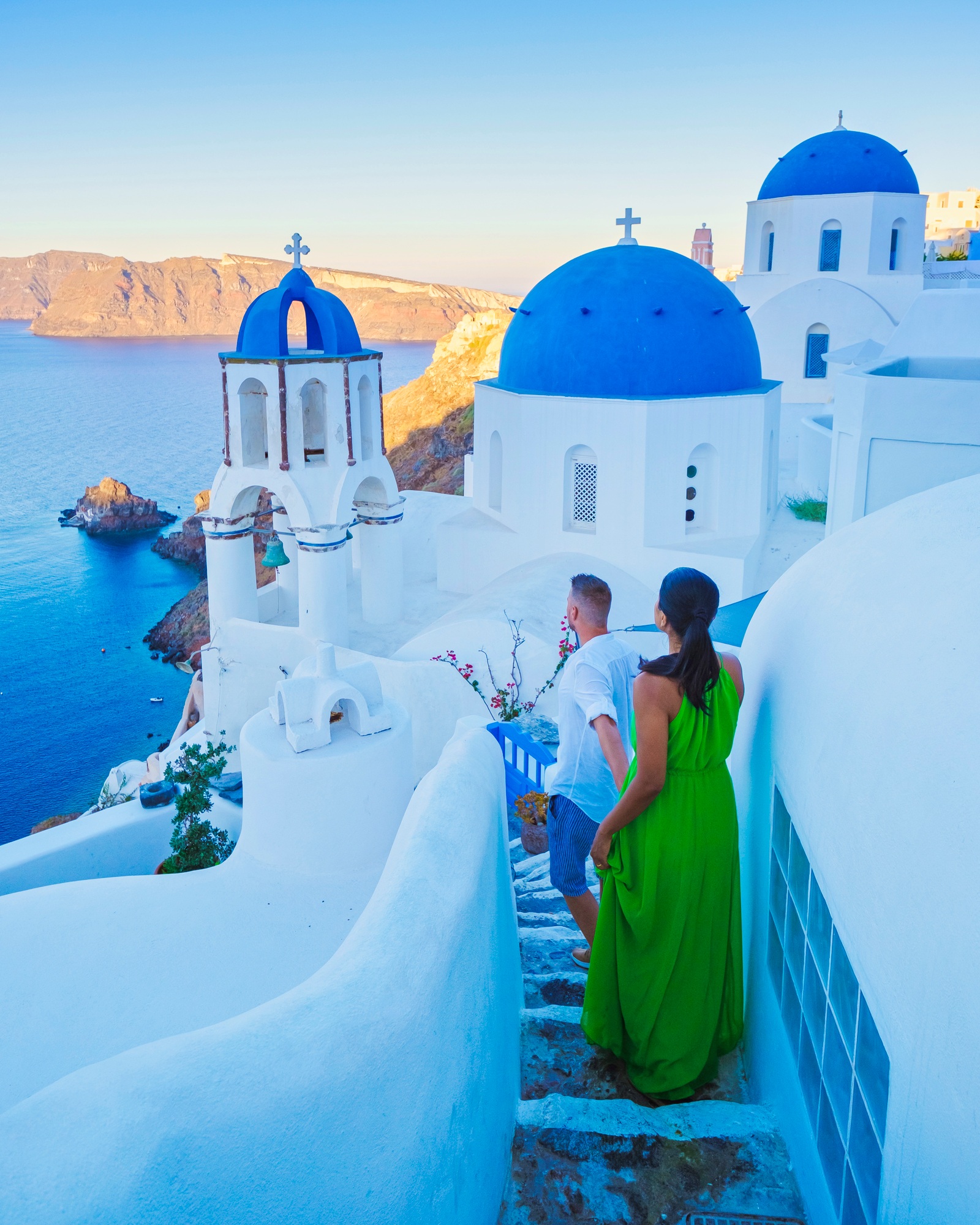 Couple walking at the Greek village of Oia Santorini Greece, men and women on vacation in Greece